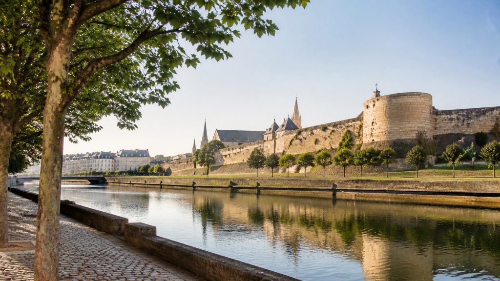 Vue photoréaliste de Caen en Normandie avec les remparts du château, les berges de l’Orne et une promenade arborée au lever du jour